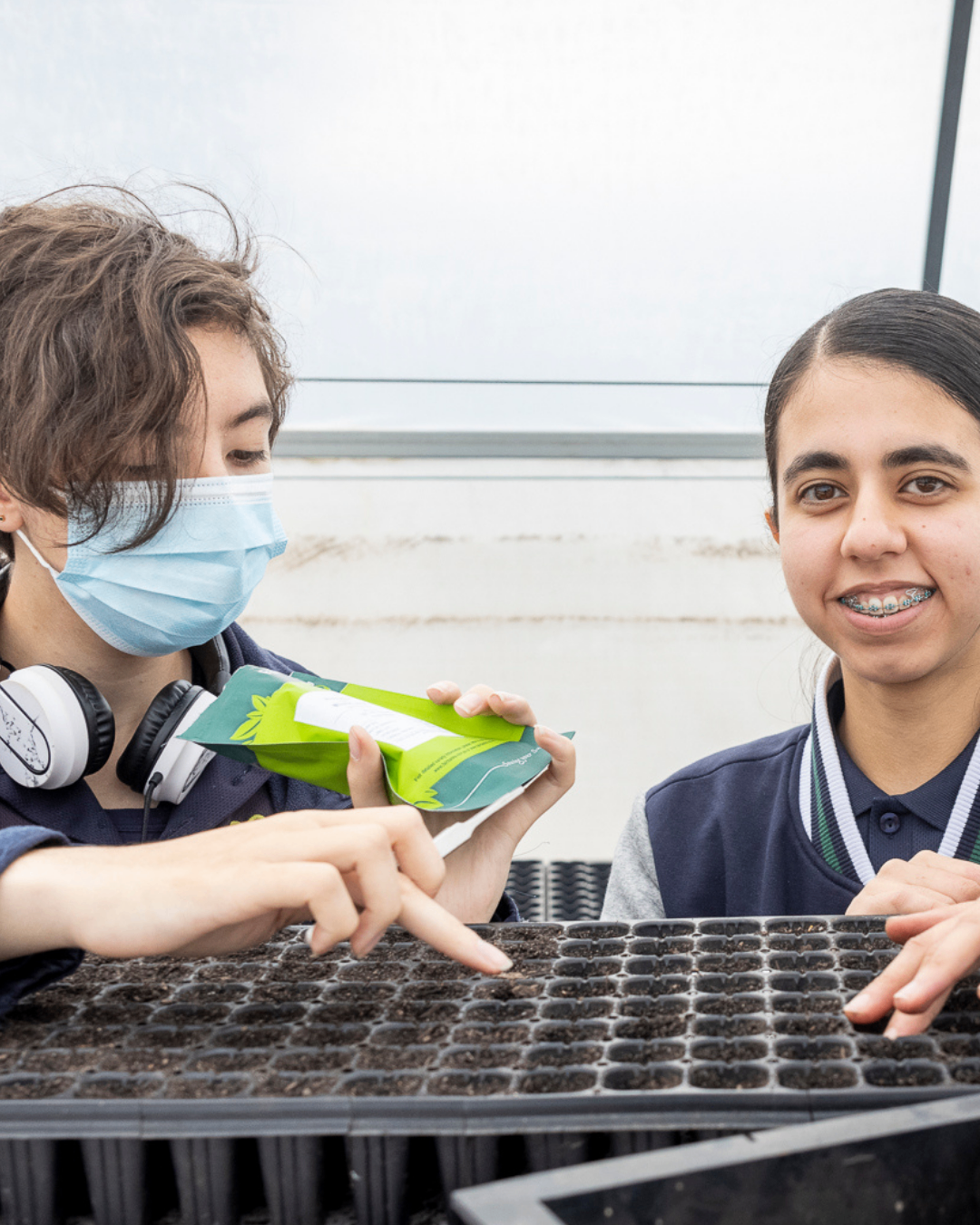 Students preparing seed trays in a greenhouse learning environment